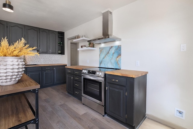 kitchen with open shelves, wall chimney range hood, stainless steel electric range, and wood counters