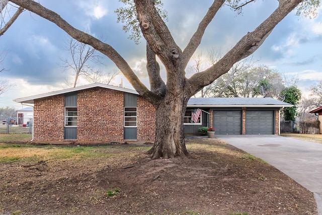 2016 China, Brady, TX 76825 - view of front of home featuring driveway, brick siding, an attached garage, and fence