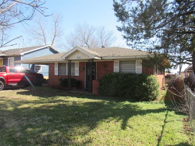 ranch-style house featuring a front yard and brick siding