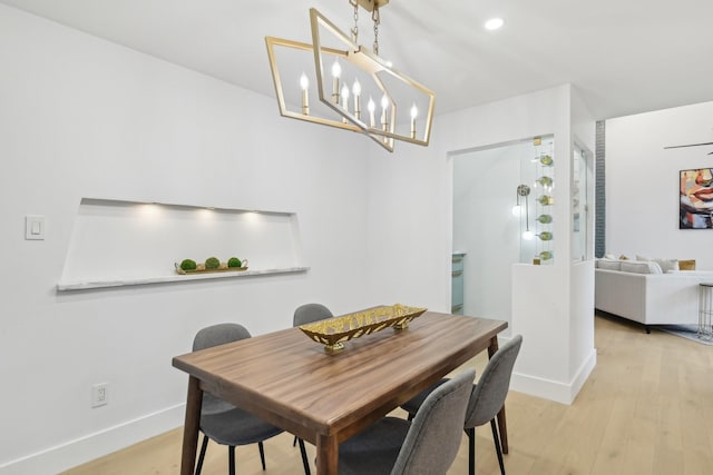 dining space with an inviting chandelier, light wood-style flooring, recessed lighting, and baseboards