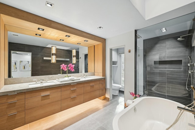 full bathroom with double vanity, a bathtub, a shower stall, and a sink