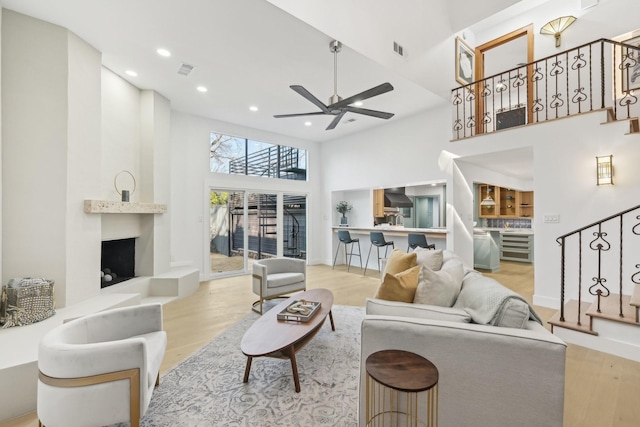 living area with stairway, a high ceiling, and wood finished floors