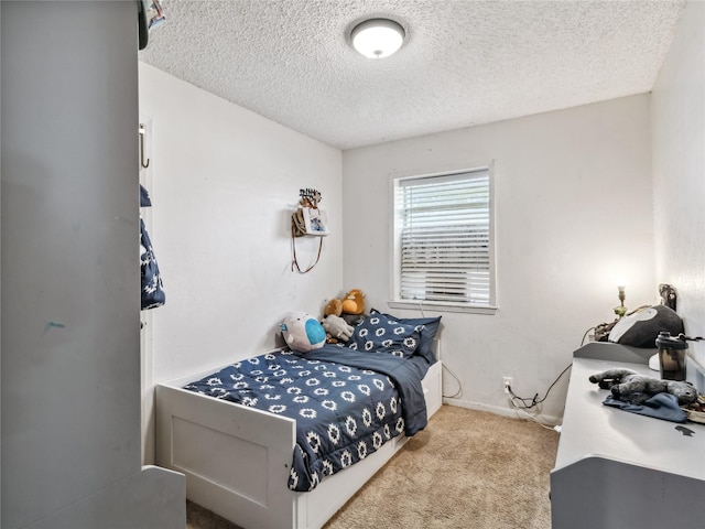 bedroom with carpet flooring, baseboards, and a textured ceiling