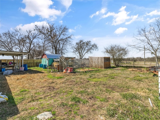 view of yard with an outdoor structure, fence, and exterior structure