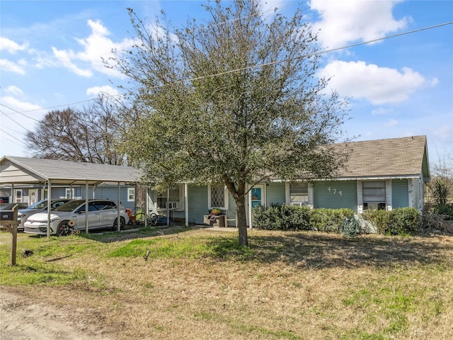 view of front facade with a detached carport and a front lawn