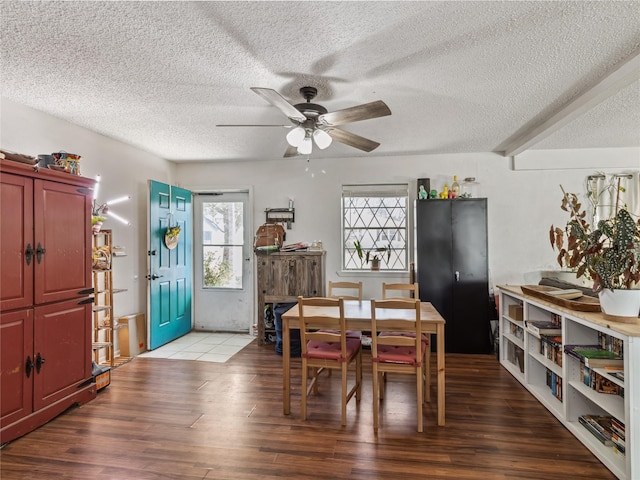 dining space with ceiling fan, a textured ceiling, and wood finished floors