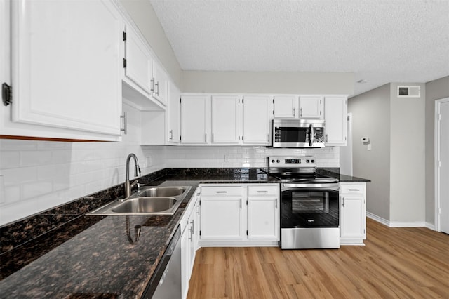 kitchen featuring a sink, stainless steel appliances, visible vents, and white cabinetry