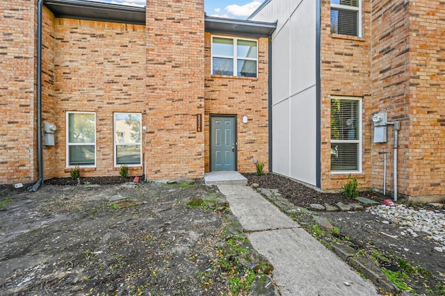 view of exterior entry with brick siding