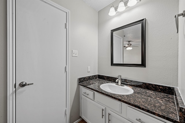 bathroom with a textured ceiling, vanity, and ceiling fan