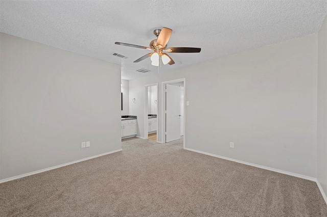 spare room featuring light carpet, visible vents, and baseboards