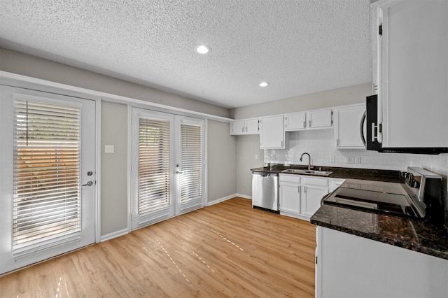 kitchen featuring a sink, tasteful backsplash, light wood-style floors, and dishwasher