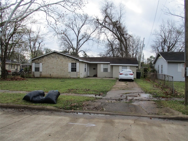 view of front of home with stone siding, a front yard, and driveway