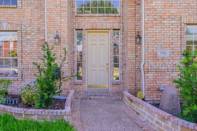 entrance to property featuring brick siding