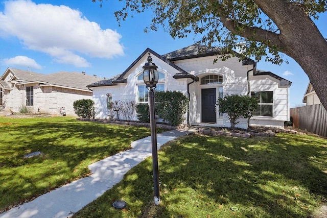 view of front facade featuring a front yard and fence