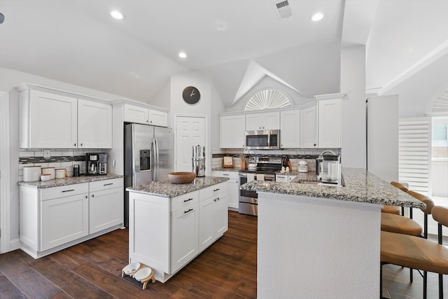 kitchen with a sink, stainless steel appliances, a peninsula, and dark wood-style flooring