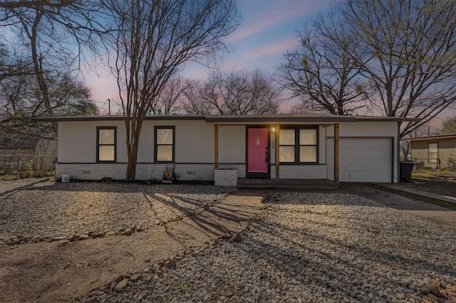 view of front of house featuring brick siding, a garage, and driveway