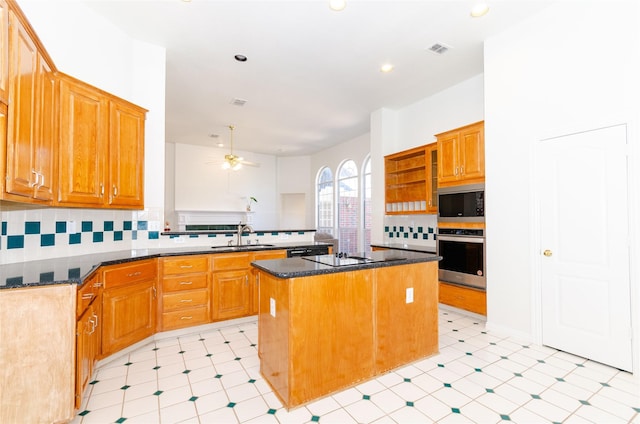 kitchen with decorative backsplash, a peninsula, appliances with stainless steel finishes, and a sink