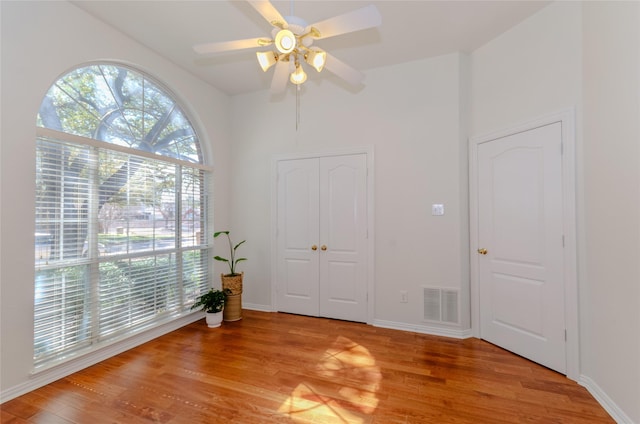 interior space with visible vents, baseboards, a ceiling fan, and light wood finished floors