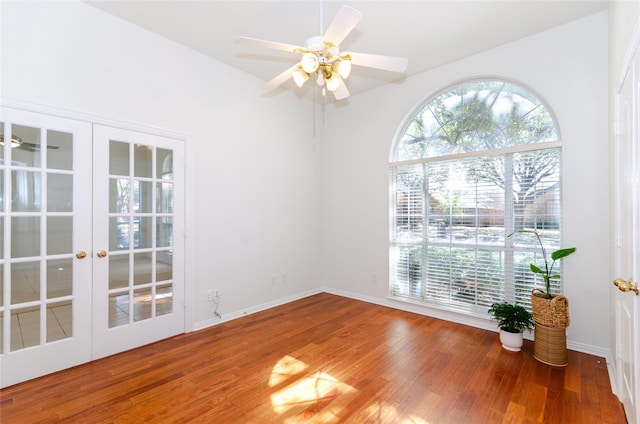 unfurnished room with ceiling fan, french doors, baseboards, and wood finished floors