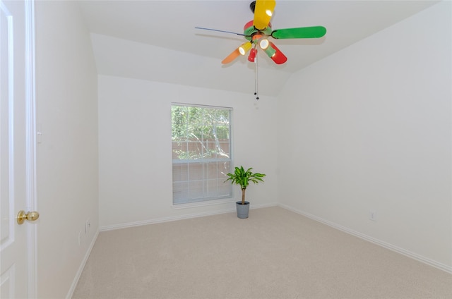 empty room with lofted ceiling, a ceiling fan, baseboards, and carpet floors