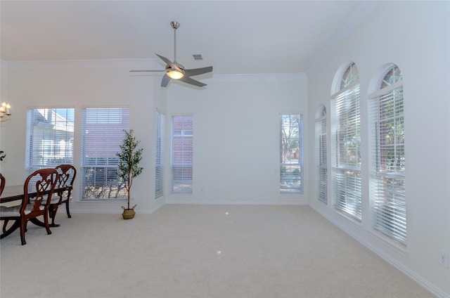 interior space featuring visible vents, ceiling fan with notable chandelier, carpet floors, crown molding, and baseboards