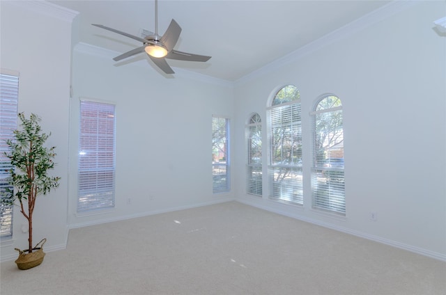 carpeted empty room with baseboards, crown molding, and a ceiling fan