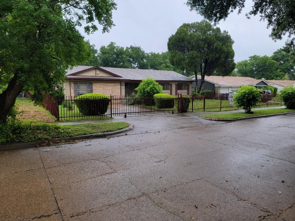 ranch-style home with a fenced front yard and brick siding