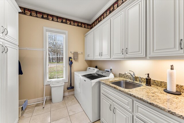 laundry area with crown molding, washer and clothes dryer, light tile patterned floors, cabinet space, and a sink