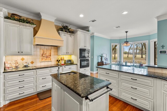 kitchen with visible vents, custom range hood, dark wood-style floors, wall oven, and built in microwave