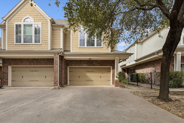 townhome / multi-family property featuring concrete driveway, brick siding, and a garage