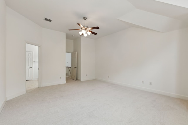 unfurnished room with a ceiling fan, visible vents, baseboards, vaulted ceiling, and light carpet