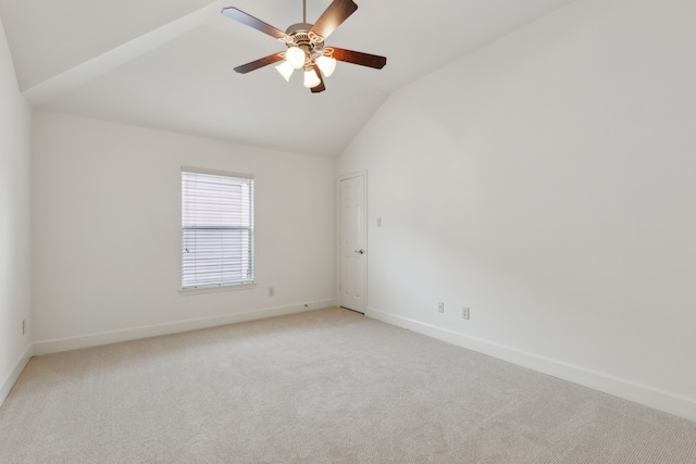 empty room with light colored carpet, baseboards, lofted ceiling, and ceiling fan