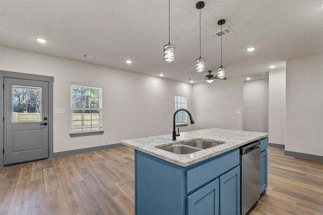 kitchen with light wood finished floors, stainless steel dishwasher, blue cabinets, and a sink