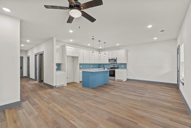 kitchen featuring visible vents, white cabinets, appliances with stainless steel finishes, and open floor plan