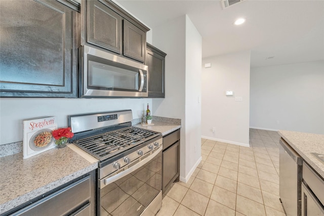 kitchen with visible vents, baseboards, dark brown cabinetry, light tile patterned floors, and appliances with stainless steel finishes