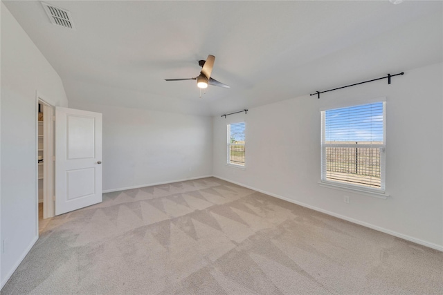 empty room with visible vents, light colored carpet, baseboards, and ceiling fan