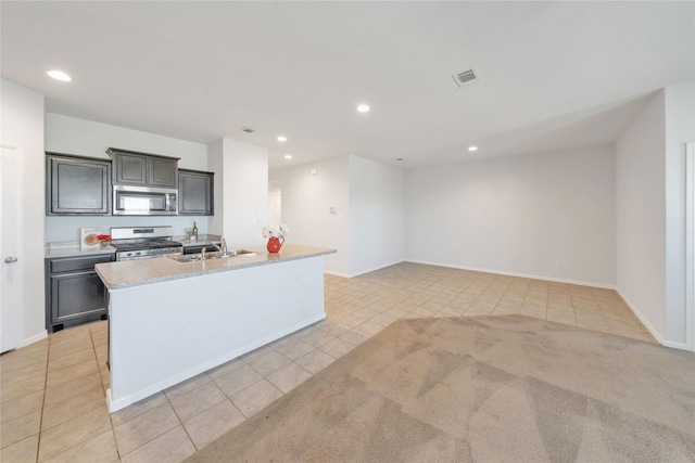 kitchen featuring visible vents, recessed lighting, a kitchen island with sink, a sink, and appliances with stainless steel finishes