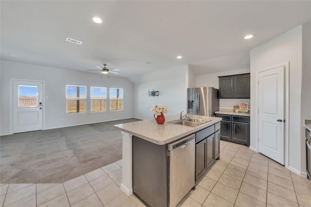 kitchen with light countertops, light carpet, light tile patterned floors, stainless steel appliances, and a sink