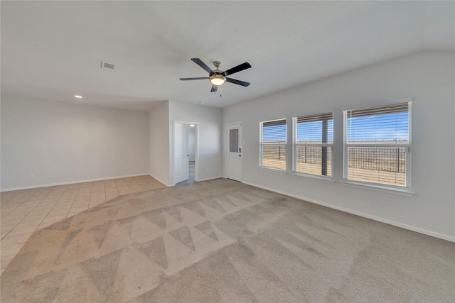 carpeted spare room featuring tile patterned flooring, visible vents, a ceiling fan, and baseboards