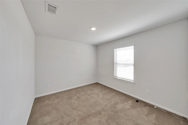 empty room featuring carpet flooring, baseboards, and visible vents