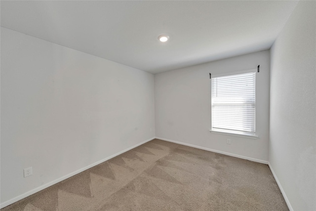 empty room featuring baseboards and carpet floors