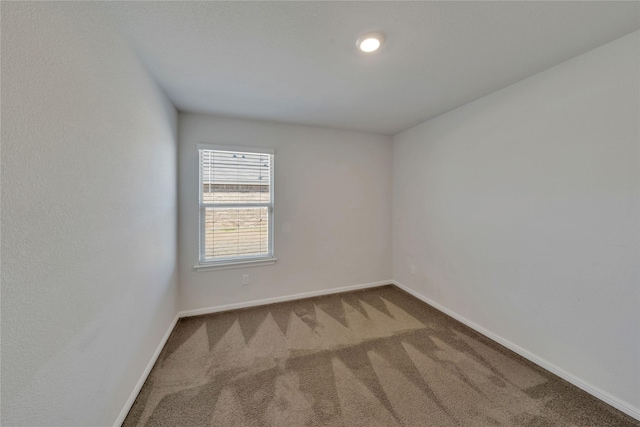 spare room with baseboards and carpet