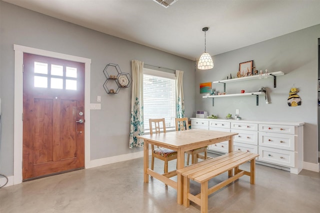 dining area with baseboards and finished concrete flooring