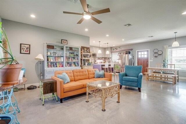 living room featuring visible vents, baseboards, ceiling fan, concrete flooring, and recessed lighting