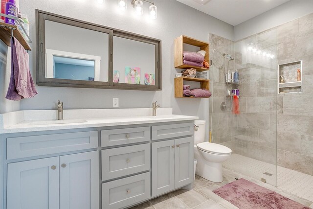 full bath with double vanity, toilet, a walk in shower, and a sink
