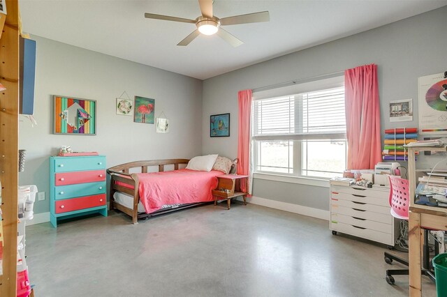 bedroom featuring a ceiling fan, concrete flooring, and baseboards