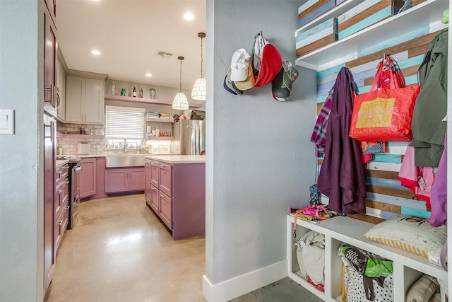 mudroom featuring a sink, visible vents, baseboards, and concrete flooring