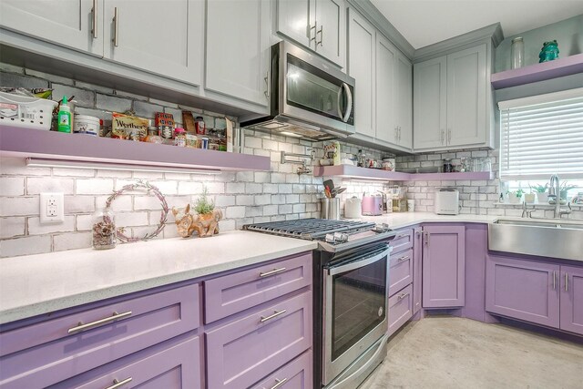 kitchen featuring a sink, stainless steel appliances, open shelves, and light countertops