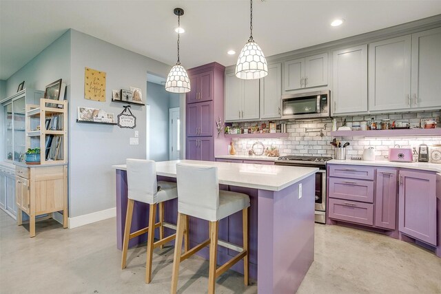 kitchen with a kitchen island, decorative backsplash, light countertops, concrete flooring, and appliances with stainless steel finishes