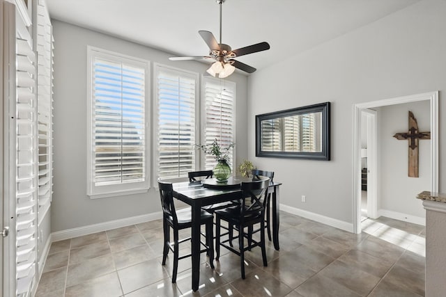 dining area featuring baseboards, light tile patterned flooring, and a ceiling fan